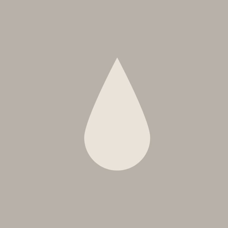 Felsen am Meer unter einem klaren blauen Himmel mit sanften Wellen.